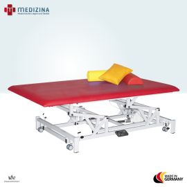 Abb. zeigt Behandlungsliege Bobath-Vojta mit Lagerungshilfen (optional wählbar). Elektrisch höhenverstellbar mit großer Polsterfläche.